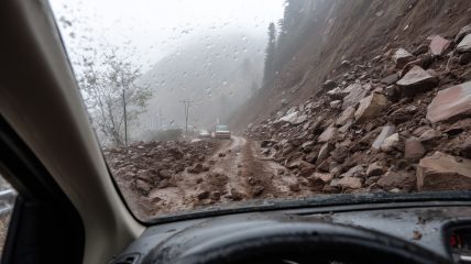 Jord- og steinras sett fra innsiden av en bil.